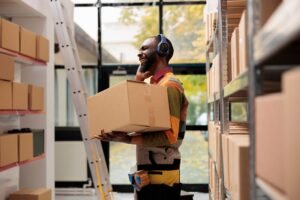 Storage room manager carrying cardboard boxes